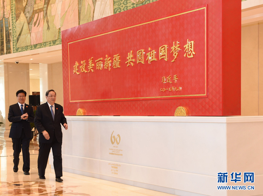 這是俞正聲和中共中央政治局委員、新疆維吾爾自治區(qū)黨委書記張春賢一同為習近平總書記題詞賀匾揭幕。新華社記者 高潔 攝 