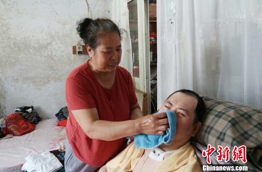 每次喂完食物后，梁青蘭都要仔細地幫兒子清理干凈。　尚明俠 攝